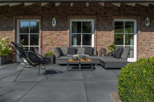 Pflastersteine METTEN UMBRIANO Grauanthrazit auf einer modernen Terrasse mit gemütlicher Lounge-Ecke.