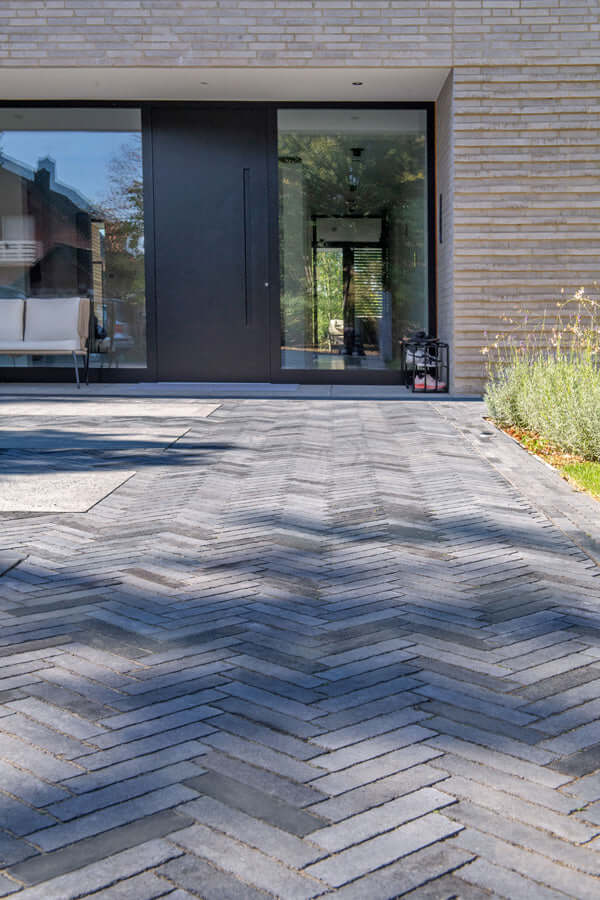 Pflastersteine METTEN SPRING ALVAR Dunkelgrau auf einer modernen Terrasse in elegantem Zickzackmuster.