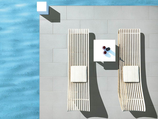 Terrassenplatte METTEN SPRING SORENO Granithell mit Holzliegestühlen am Pool.