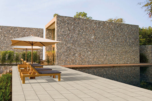 Terrassenplatte METTEN SPRING SORENO Toscanabeige auf einer modernen Terrasse mit Pool und Sonnenschirmen