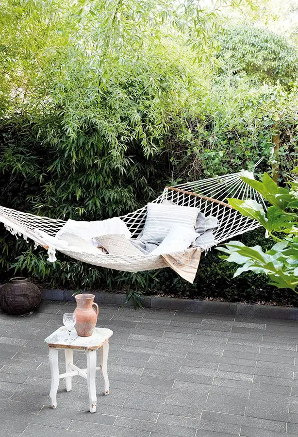 Pflastersteine METTEN UMBRIANO Platingrau um eine entspannende Hängematte im Garten.